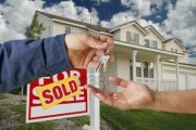 handing-over-the-keys-to-a-new-home-with-sold-home-for-sale-sign